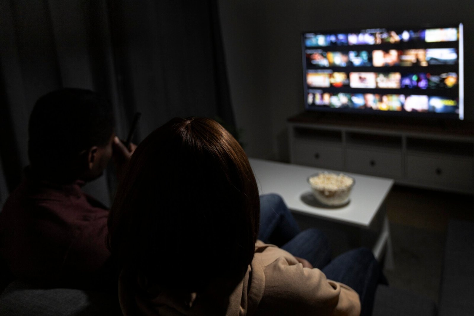 Casal assistindo serviço de streaming juntos em um sofá